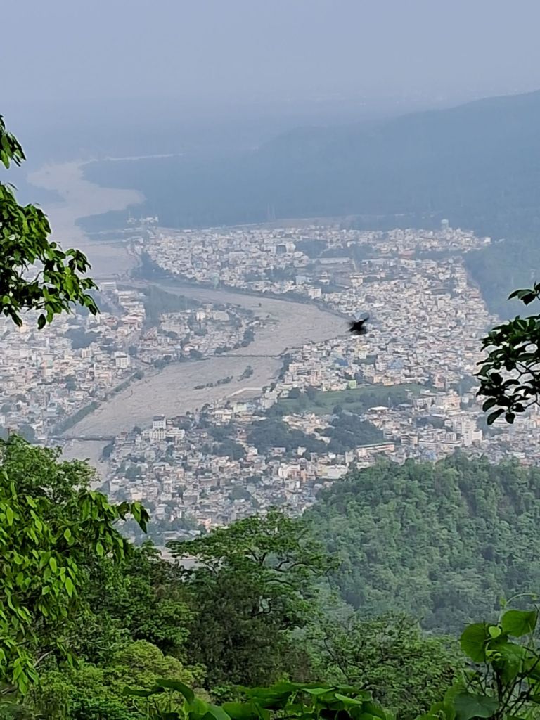 An image of the view of the Hrishikesh city and Ganga river from the top.