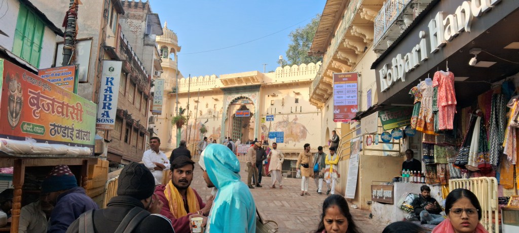 Exterior view of Shrinath Ji Temple seen from Shreenath Ji Chowk in Nathdwara, Rajasthan, showing the temple façade, surrounding buildings, and a lively devotional atmosphere.