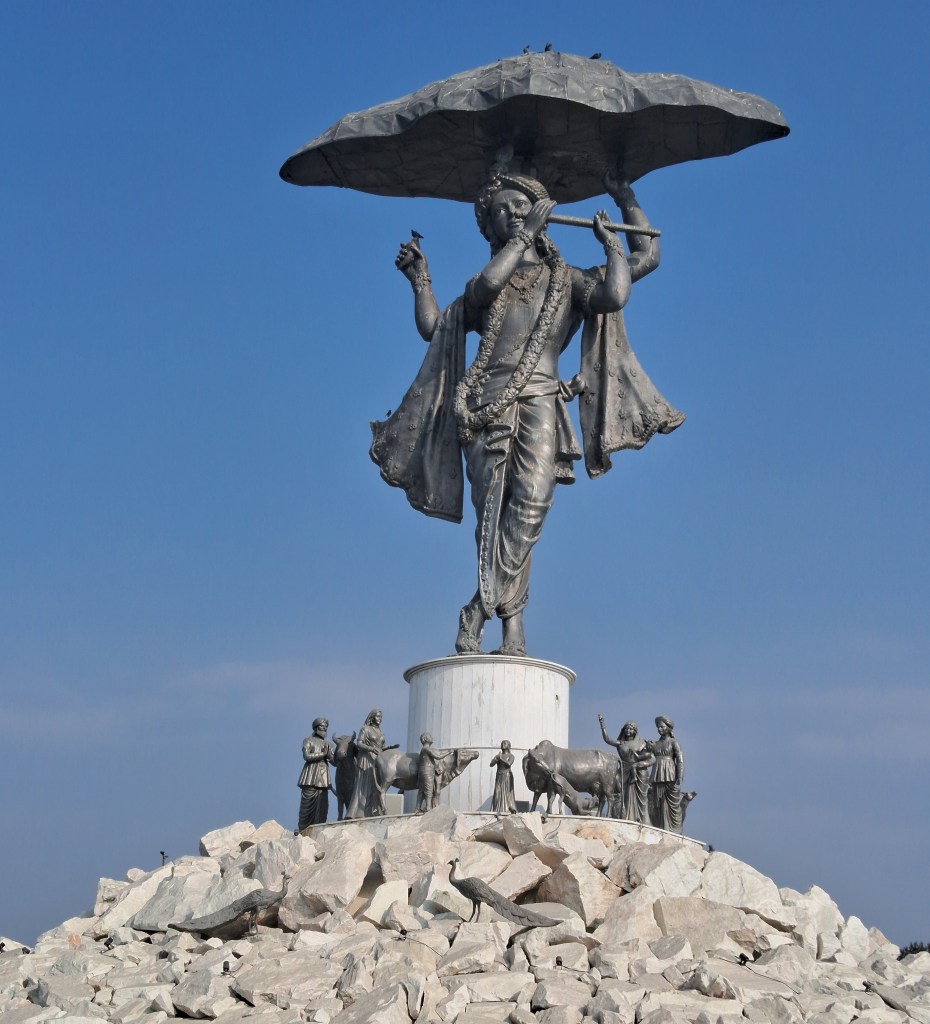 Statue of Shree Krishna lifting Govardhan Hill in Nathdwara, depicting the divine moment of protection, with detailed sculpture and a serene devotional setting.