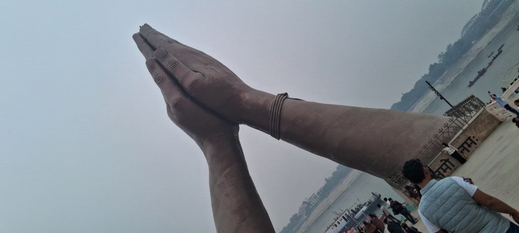 A captivating view of Namo Ghat in Varanasi, featuring its iconic giant namaste hand sculptures welcoming visitors along the pristine Ganga riverfront.