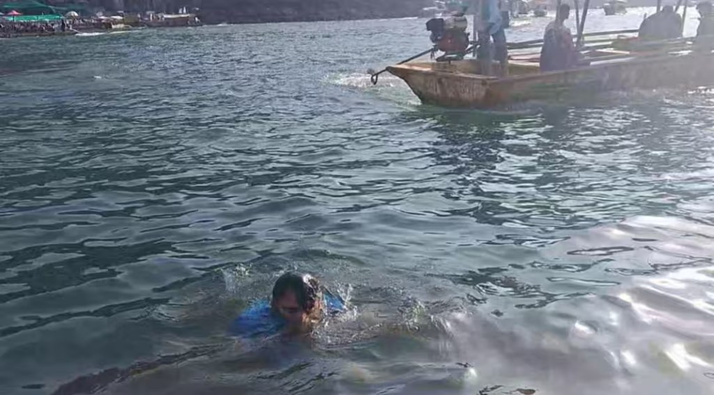 Spiritual bathing ritual in the sacred Narmada River at Omkareshwar pilgrimage site.